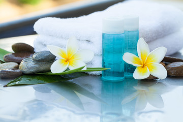 Two flowers and little bottles with oil for massage