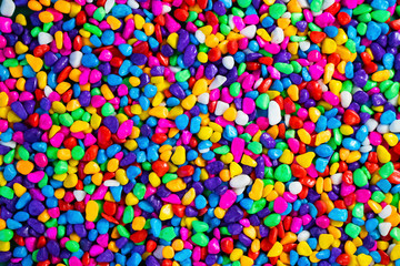 Multi-colored painted sea pebbles. Bright background.