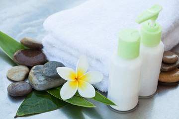Fototapeta na wymiar Body care and spa concept with bottles and flower and stones