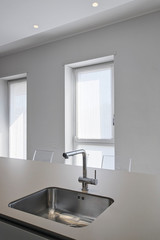 interiors shots of a modern ktichen, in the foreground the steel sink integrated and the water faucet