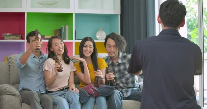 Group of young friends partying and enjoying to taking photo on couch together at home. People with party and celebration concept.