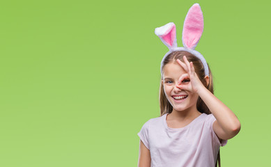 Young beautiful girl wearing easter bunny ears over isolated background doing ok gesture with hand...