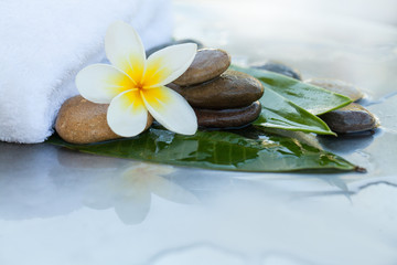 Fototapeta na wymiar Stones, flower, towel and leaves for massage
