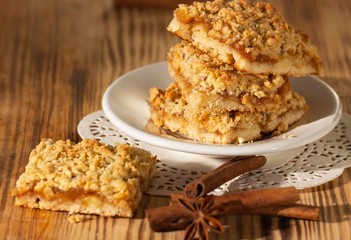 homemade apple pie on a white plate which stands on an old wooden table close-up with a copy space