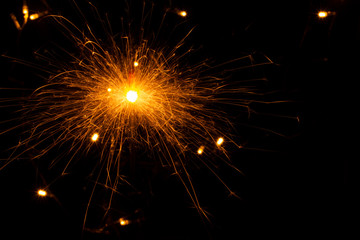 Fototapeta na wymiar festive background with sparkler and new year lights closeup