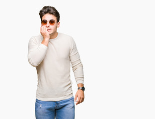 Young handsome man wearing sunglasses over isolated background looking stressed and nervous with hands on mouth biting nails. Anxiety problem.