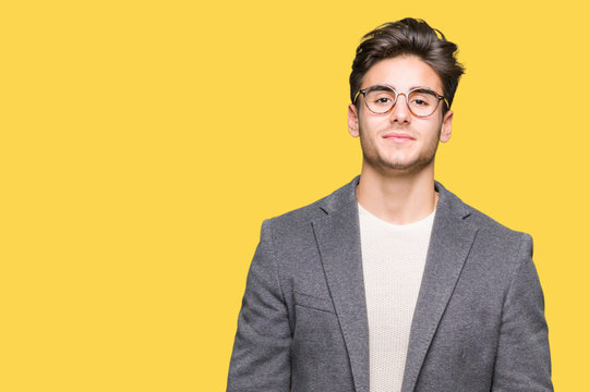Young business man wearing glasses over isolated background Relaxed with serious expression on face. Simple and natural looking at the camera.