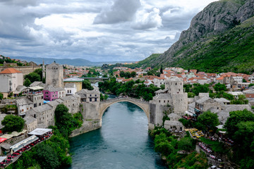 Fototapeta na wymiar Storm clouds gather over the beautiful ancient Stari Most bridge which proudly spans the Neretva river, connecting the two halves of the city of Mostar for centuries.