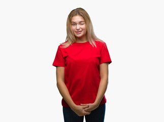 Young caucasian woman over isolated background winking looking at the camera with sexy expression,...