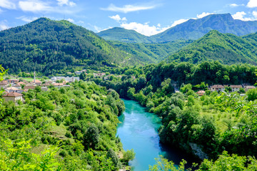 Fototapeta na wymiar Azure brook flowing through the verdant countryside of Bosnia and Herzegovina