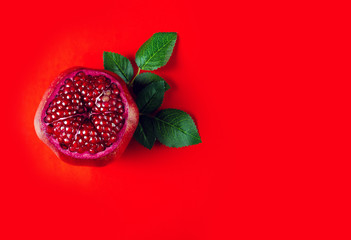 Pomegranate red fruit on red background, top view