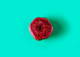 Pomegranate red fruit on green background, top view