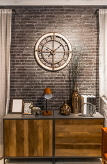 wooden retro style sideboard with vintage loft design clock on brick wall, decoration and interior concept