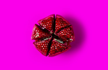 Pomegranate red fruit on pink background, top view