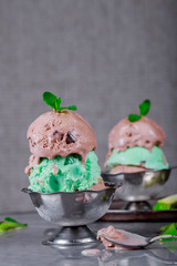 Pistachio ice cream with chocolate and mint leaves stone background, selective focus