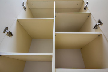 Interior of white plastic cabinet or clothing wardrobe with many empty shelves with open doors....
