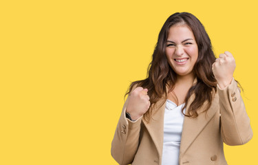 Beautiful plus size young woman wearing winter coat over isolated background very happy and excited doing winner gesture with arms raised, smiling and screaming for success. Celebration concept.