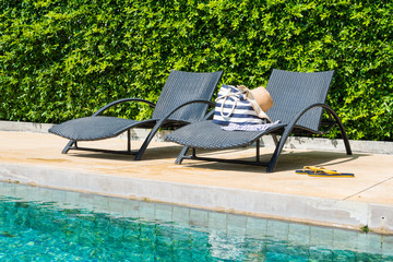 chair on luxury swimming pool with bag and hat