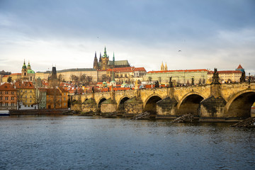 Panorama of Charles bridge and Prague castle over Vltava river in cloudy day, Czech Republic