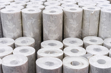 Rolls of wallpaper with a picture on the counter of the store.