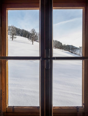 Austrian winter landscape viewed throug a wooden window