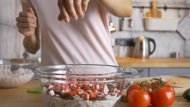 add crab sticks into a bowl with salad