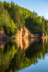 blue sky and clouds reflecting in calm water of river Gauja in latvia in autumn