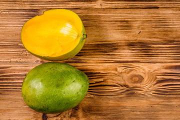 Halved mango fruit on a wooden table. Top view