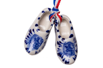 Holland wooden clogs. A pair of traditional dutch porcelain shoes with a ribbon flag isolated on a...