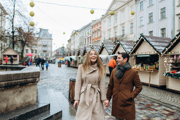 Beautiful lovely couple walking around the central square of the Christmas Europe city