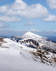 View of the stony hills with snow and blue sky. Dramatic spring scene. Landscape photography