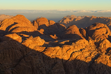 Picturesque landscape of mountain peaks during sunrise. Sinai Mountain (Mount Horeb, Gabal Musa, Moses Mount). Sinai Peninsula of Egypt. Thick fog in the background. Famous touristic destination