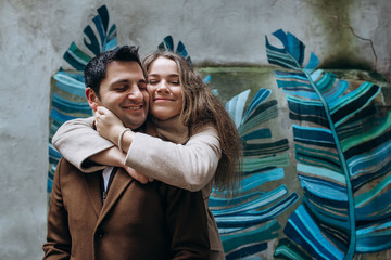 Beautiful lovely smiling couple have fun on street art background
