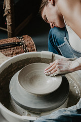 Creating a jar or vase of white clay close-up. Woman hands making clay jug.