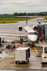 Ground crewsman prepares jet plane for flight at Albany International Airport