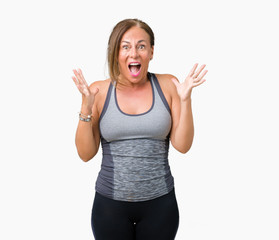 Fototapeta na wymiar Beautiful middle age woman wearing sport clothes over isolated background celebrating crazy and amazed for success with arms raised and open eyes screaming excited. Winner concept