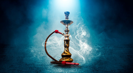 Hookah smoking on a concrete background, illuminated by the spotlight, neon light, smoke