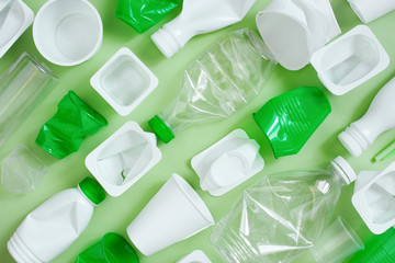 Various plastic garbage on the light green background