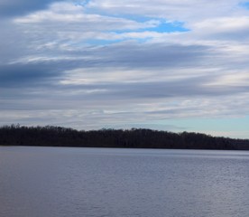 The clouds in the sky over the lake in the park.
