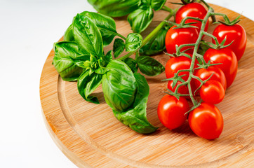 The branch of cherry tomatoes on a wooden background.