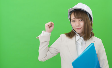 ヘルメットと作業服の女性　ガッツポーズ　グリーンバック