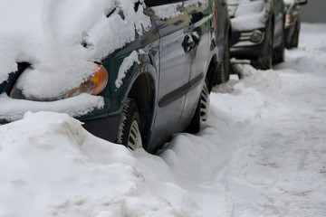 the car parked on the street which is filled up with snow