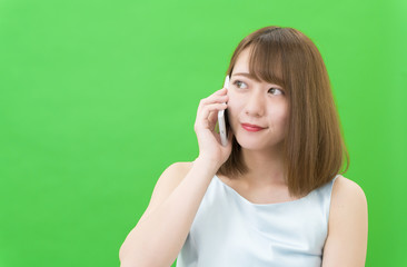 若い女性　スマホで会話　