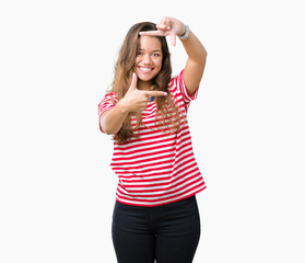 Obraz na płótnie Canvas Young beautiful brunette woman wearing stripes t-shirt over isolated background smiling making frame with hands and fingers with happy face. Creativity and photography concept.