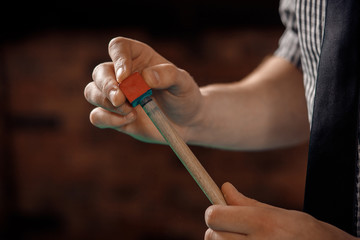 Man player sharpens cue in billiards on green table with chalk