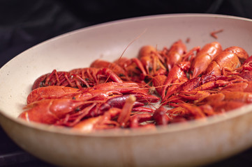 Boiled crayfish with dill on frying pan