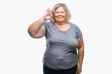 Fototapeta premium Senior plus size caucasian woman over isolated background smiling positive doing ok sign with hand and fingers. Successful expression.