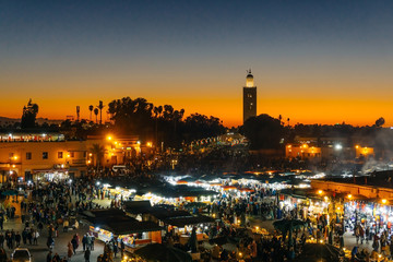 Fototapeta na wymiar Marrakesh Medina (Marrakech Medina). Jamaa el Fnaa square or Jemaa el-Fna, Djema el-Fna, Djema el-Fnaa market place and Koutoubia mosque minaret