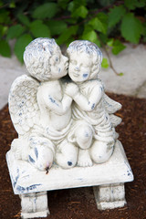 Küssende Engel knien auf einer Bank