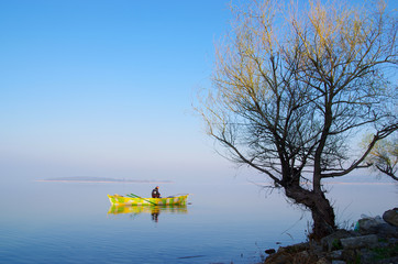 Golyazi, Bursa / Turkey - March 15 / 2014 : A fisherman with yellow boat passing through a yellow branched tree